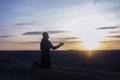 Prayer. Man on his knees praying. Against the background of the sky and sunset. Forgiveness of sins and repentance. Royalty Free Stock Photo