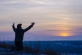 Prayer. Repentance. Silhouetted men on a background of blue sky and sunset. Kneeling Prayer to God. Glorification. Praising God