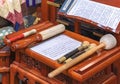 Prayer room of a Japanese temple with sutra booklets on a wooden table and buddhist drum sticks.