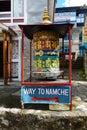 Prayer wheel with sign to Namche Bazaar in Phakding, Everest Base Camp trek, Nepal Royalty Free Stock Photo