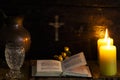 Prayer on wood table, candle and cross. The concept of waiting for Christmas. 11/22/2019. Montenegro. Royalty Free Stock Photo