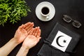 Praying concept with hands, Koran Islam holy book, crescent and star on black table top view