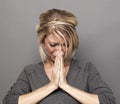 Praying concept for heart-broken young blond woman