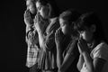 Praying family on dark background Royalty Free Stock Photo