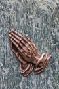 Praying hands as bronze figure on a graveyard grave as religious symbol for faith christianity blessing catholic priest and belief Royalty Free Stock Photo