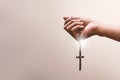 Praying hands hold a crucifix or cross of metal necklace with faith in religion and belief in God on confession background. Power Royalty Free Stock Photo