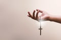 Praying hands hold a crucifix or cross of metal necklace with faith in religion and belief in God on confession background. Power Royalty Free Stock Photo