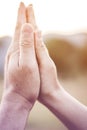 Praying hands in meadow at sunset Royalty Free Stock Photo