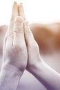 Praying hands in meadow at sunset Royalty Free Stock Photo