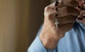 Praying hands of an old man holding rosary beads. Royalty Free Stock Photo