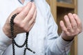 Praying hands of an old man holding rosary beads Royalty Free Stock Photo