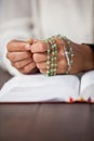 Praying hands of woman with a rosary on bible Royalty Free Stock Photo