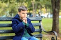 Praying little boy sitting on bench in park Royalty Free Stock Photo