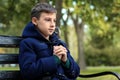 Praying little boy sitting on bench in park Royalty Free Stock Photo