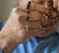 Praying old man with hands holding rosary beads. Royalty Free Stock Photo