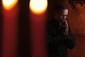 Praying priest. Portrait of priest Next to the candles prays Royalty Free Stock Photo