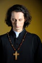 Praying priest with wooden cross