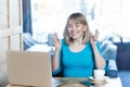 Praying! Side view portrait of wishful attractive young girl freelancer in blue t-shirt are sitting in cafe and working on laptop