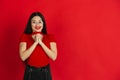 Caucasian young woman`s monochrome portrait on red studio background, emotional and expressive Royalty Free Stock Photo