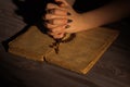 Praying to God, folded Christian woman hands with holy bible and rosary.