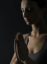 Praying woman. Prayer close up portrait, black bac