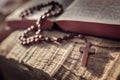 Praying with wooden rosary beads crucifix cross on Holy Bible background Royalty Free Stock Photo
