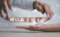 Praying and worship concept, Hand hold cubes woods block on table with word worship on cubes woods block on the White background,