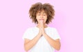 Praying young afro american girl. African woman in summer shirt isolated on pink background. Copy space. Mock up. Make a wish Royalty Free Stock Photo