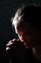 Praying young Woman portrait on dark