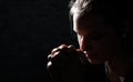Praying young Woman portrait on dark