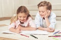 Pre-adolescent kids drawing pictures while lying on the floor at home Royalty Free Stock Photo