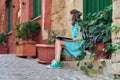 Pre-adolescent schoolgirl with a book sitting on steps of outdoor