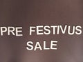 Pre festivus sale sign on a brown background