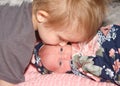 Pre School brother kissing newborn baby sister, baby looking at viewer