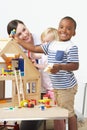 Pre-School Teacher And Pupils Playing With Wooden House Royalty Free Stock Photo