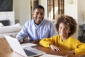 Pre-teen African American  girl and her male home tutor sitting at a table in the dining room smiling to camera, close up Royalty Free Stock Photo