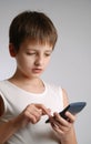 Pre-teen boy with mobile phone on light background