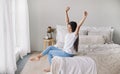 Beautiful pre-teen girl in casual clothes do stretching exercises seated on bed in cozy bedroom in the morning Royalty Free Stock Photo