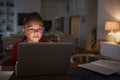 Pre-teen Hispanic boy sitting at dining table doing his homework using a laptop computer, close up Royalty Free Stock Photo