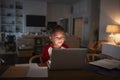 Pre-teen Hispanic boy sitting at dining table doing his homework using a laptop computer, front view Royalty Free Stock Photo