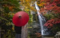 Pre wedding photo for Japanese couple and red umbrella on the red bridge in minoh waterfallrfall park with autumn red and yellow Royalty Free Stock Photo