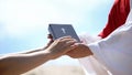Preacher in robe passing bible to male hands, spreading religious teachings Royalty Free Stock Photo