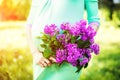 Preagnant woman in the park with purple flowers