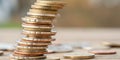 A precarious stack of coins teeters, symbolizing financial instability and risk. The blurred background adds to the uncertain Royalty Free Stock Photo