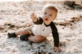 Precious Adorably Cute Happy Baby Boy Toddler Smiling and Playing in the Sand At the Beach Next to the Ocean Water Outside During Royalty Free Stock Photo