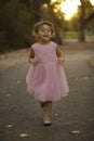 Precious ittle girl in pink dress running at dusk Royalty Free Stock Photo