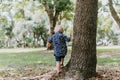 Precious Little Toddler Boy Dressed Up in the Outdoors Forest Park for Portraits in Autumn by Big Natural Tree Having Excited Fun Royalty Free Stock Photo