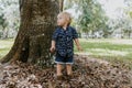 Precious Little Toddler Boy Dressed Up in the Outdoors Forest Park for Portraits in Autumn by Big Natural Tree Having Excited Fun Royalty Free Stock Photo