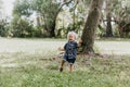 Precious Little Toddler Boy Dressed Up in the Outdoors Forest Park for Portraits in Autumn by Big Natural Tree Having Excited Fun Royalty Free Stock Photo