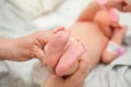 a nurse holds the legs of a newborn baby in her hands